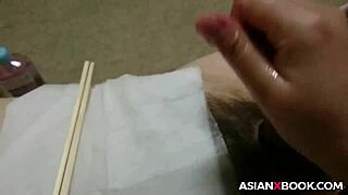 In a homemade setting, an Asian babe skillfully uses chopsticks for an intense handjob session with her amateur partner.
