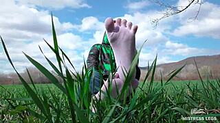 Adoring her cute feet in white socks on spring grass with jeans.