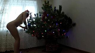 bitch with small tits dances around christmas tree showing ass and pussy