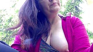 Nicoletta lights up a smoke in a public garden and boldly flashes her large tits by exposing them from her shirt