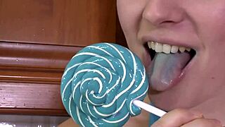 brunette sucks on a lollipop while wearing high heels.