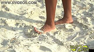 Giggles rubs long hair feet on huge hot rock at beach