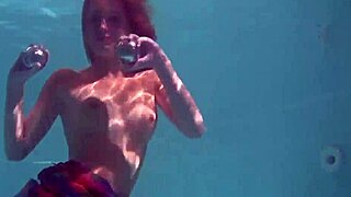 Redhead babe Nikita Vodorezova strips naked quickly in underwater pool scene