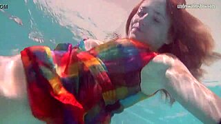 Redhead babe Nikita Vodorezova strips naked quickly in underwater pool scene