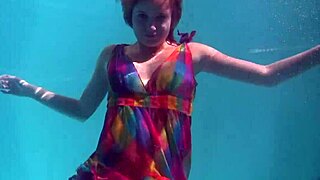 Redhead babe Nikita Vodorezova strips naked quickly in underwater pool scene